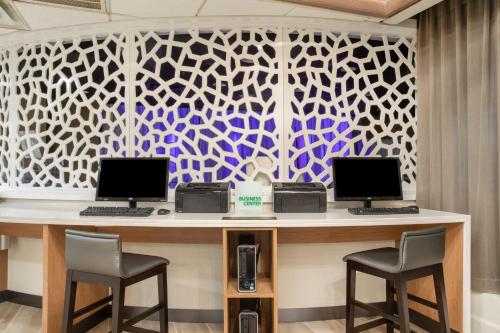a reception desk with two computers and two chairs at Holiday Inn & Suites Parsippany Fairfield by IHG in Parsippany