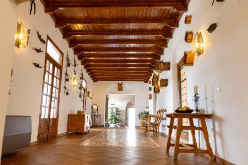 a hallway with a wooden ceiling and a table at Villa Turística de Priego in Priego de Córdoba
