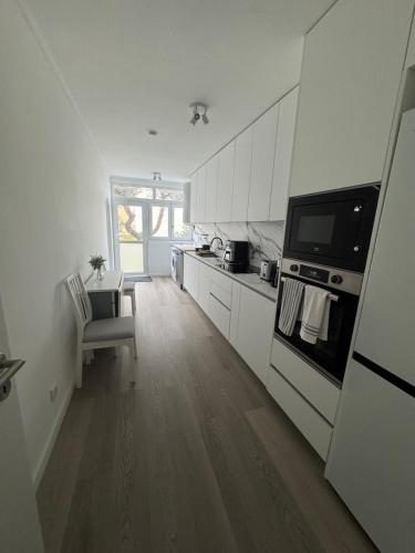 a kitchen with white cabinets and a stove at Vagueira Apartment in Praia da Vagueira