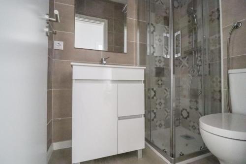 a bathroom with a sink and a shower and a toilet at Vagueira Apartment in Praia da Vagueira