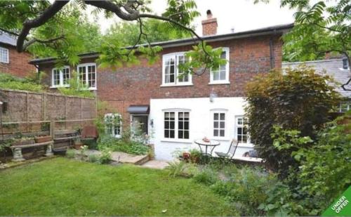 a brick house with a garden in front of it at Beautiful townhouse in perfect location in Guildford