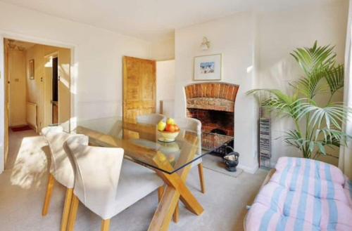 a living room with a glass table and a fireplace at Beautiful townhouse in perfect location in Guildford