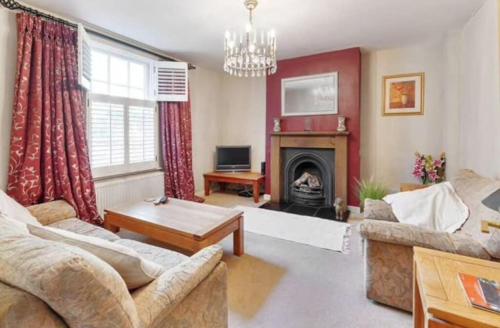a living room with a couch and a fireplace at Beautiful townhouse in perfect location in Guildford