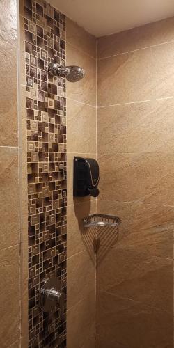 a shower with a glass door with a shower at NU Hotel in Bintulu