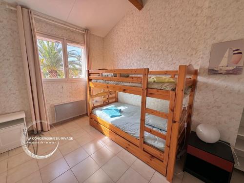 deux lits superposés dans une chambre avec fenêtre dans l'établissement Villa La Pialla - Piscine - Plages et Port à pied, à Carqueiranne