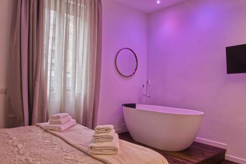 a bathroom with a white tub and a purple wall at Agave in Centrale in Milan