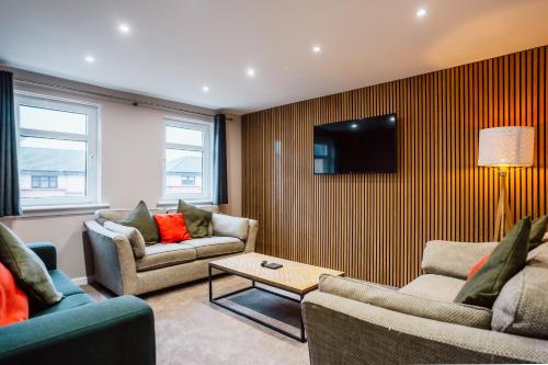 a living room with two couches and a tv at Dalmarnock Stay in Glasgow