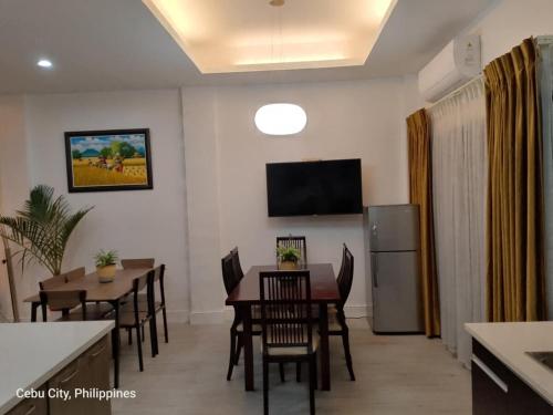 a dining room with a table and chairs and a television at Noah's Crib for Families and Big Groups in Cebu City