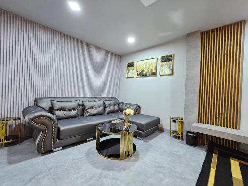 a living room with a couch and a table at Little Loft Hotel in Phuket Town