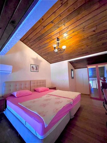 a bedroom with a large bed with a wooden ceiling at Beachwood Villas in Marmaris