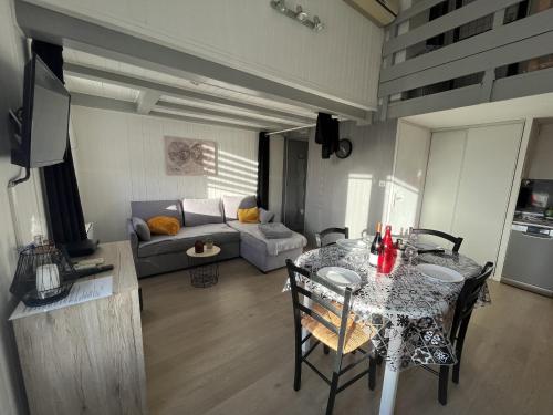 un salon avec une table et un canapé dans l'établissement Cosy Fermette, à Saint-Jean-de-Monts