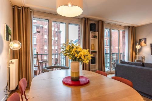 - un salon avec une table en bois et des fleurs dans l'établissement Luxury flat for 6 people with balcony - Near Metro, à Paris