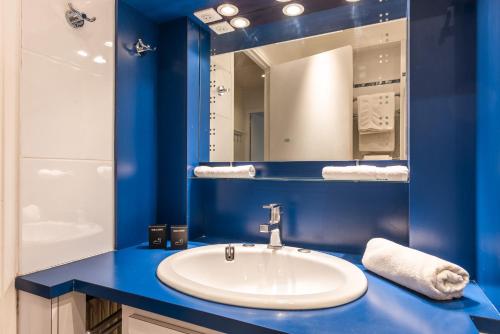 une salle de bain bleue avec un lavabo et un miroir dans l'établissement Luxury flat for 6 people with balcony - Near Metro, à Paris