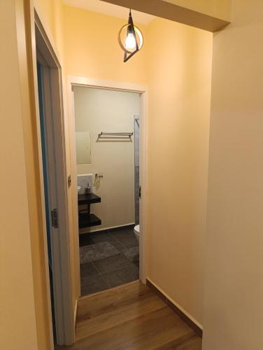 a hallway with a bathroom with a toilet and a light at Unity 1 in Tatu City