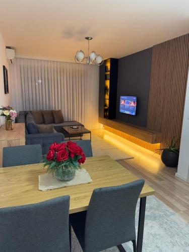 a living room with a table with red roses on it at Apartment in Kosovo Polje