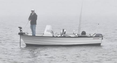 a man standing on a boat in the water at Water Villa, Houseboot at the Lake, Great Views, 70 km to Amsterdam in Biddinghuizen