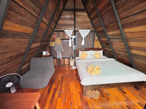 a bedroom with a bed and a chair in a room at Ma Family Coffee Farm ไร่กาแฟครอบครัวมะ in Ban Huai Pong Nam Ron