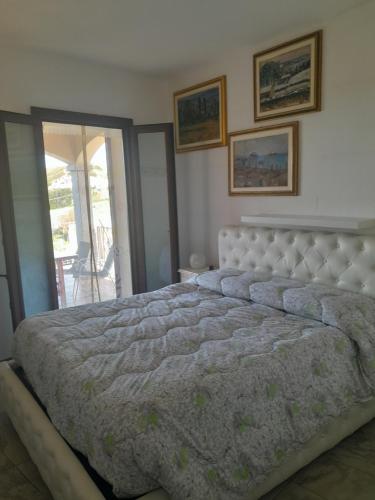 Un dormitorio con una cama grande y un balcón. en belvedere, en Castelsardo