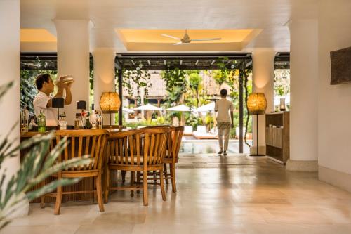 a bar in a restaurant with people walking in the background at COMO Uma Ubud in Ubud