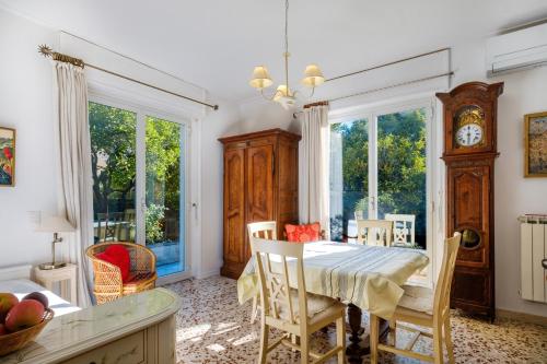 une salle à manger avec une table et une horloge au mur dans l'établissement Villa Eden 2, à Menton