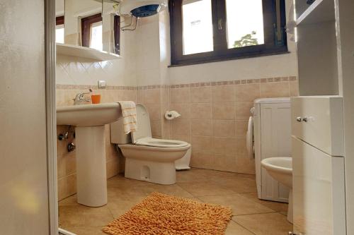 a bathroom with a sink and a toilet and a window at Terrazza Paola in Alghero