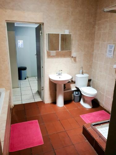 a bathroom with a sink and a toilet at Inn-Finity Empire in Witfield