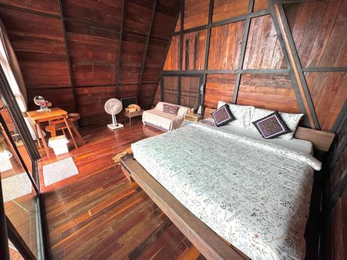 a bedroom with a bed in a wooden room at Ma Family Coffee Farm ไร่กาแฟครอบครัวมะ in Ban Huai Pong Nam Ron