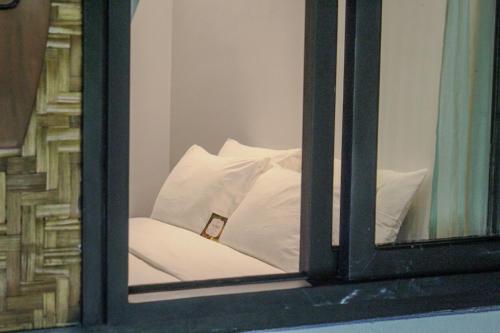 a window with a white pillow sitting on a couch at The Henry Resort Siargao at Kermit in General Luna