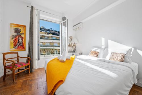 une chambre avec un grand lit et une fenêtre dans l'établissement PamPam - L'évasion lumineuse & pleine de charme, à Nice