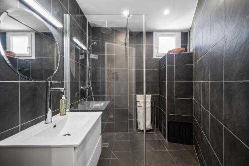 une salle de bain avec un lavabo et un miroir dans l'établissement PamPam - L'évasion lumineuse & pleine de charme, à Nice