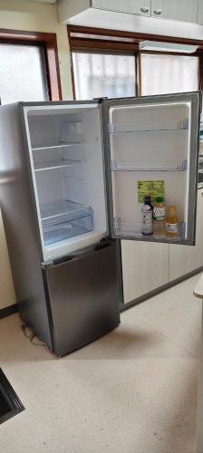an empty refrigerator with its door open in a room at 4BR BIG Private House ChoshiOcean in Choshi