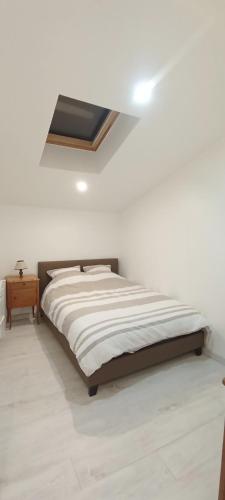 Ce lit se trouve dans un dortoir blanc doté d'une lucarne. dans l'établissement Clisson duplex dans quartier plein de charme, à Clisson