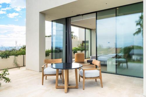 a dining room with glass walls and a table and chairs at Hermosa in San Leonardello