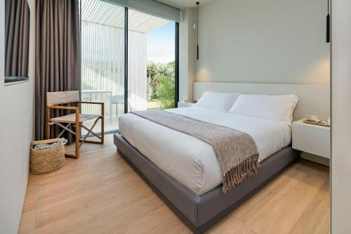 a bedroom with a large bed and a large window at Hermosa in San Leonardello