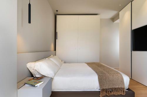 a bedroom with a white bed and a television at Hermosa in San Leonardello