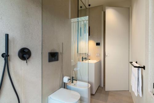 a bathroom with a white toilet and a sink at Hermosa in San Leonardello