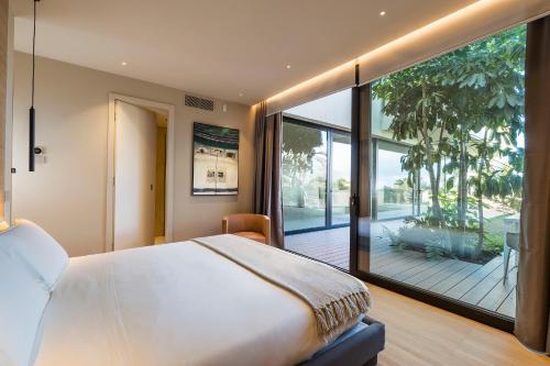 a bedroom with a large bed and a balcony at Hermosa in San Leonardello