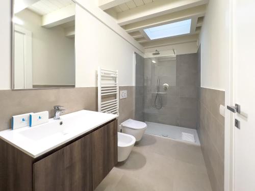 a bathroom with a sink and a toilet and a shower at Bright apartment with terrace and pool in Milan