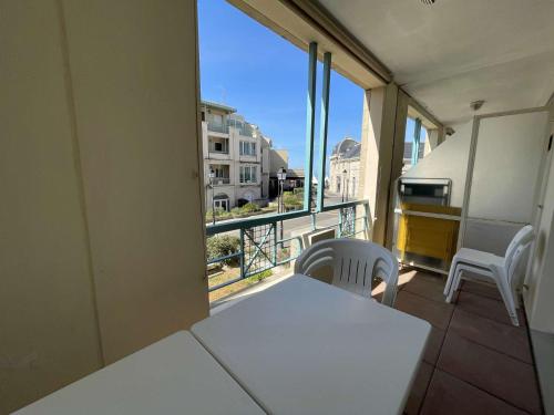 een balkon met een witte tafel en stoelen en een raam bij Appt 2 pièces CHATELAILLON PLAGE - CL040-H11 in Châtelaillon-Plage