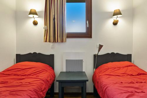 - 2 lits dans une chambre avec une table et une fenêtre dans l'établissement Résidence Les Hauts De Preclaux - Appartement rénové au coeur des Orres 1800 MAE-8511, aux Orres