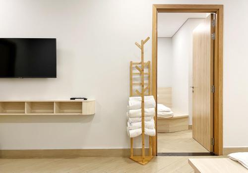 Zimmer mit einem Handtuchhalter und einem TV an der Wand in der Unterkunft 5 homestay Ocean View in Xã Thắng Nhứt