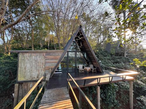 a house with a triangular roof on a wooden deck at Ma Family Coffee Farm ไร่กาแฟครอบครัวมะ in Ban Huai Pong Nam Ron