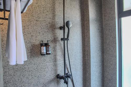 a shower in a bathroom with two bottles of shampoo at The Henry Resort Siargao at Kermit in General Luna
