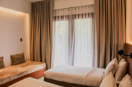 a hotel room with two beds and a window at The Henry Resort Siargao at Kermit in General Luna