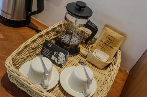 a wicker basket with two cups and a coffee pot at The Henry Resort Siargao at Kermit in General Luna