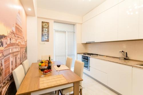 a kitchen with a table with a bowl of fruit on it at Downtown Comfort in Tbilisi City