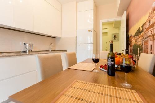 a kitchen with a wooden table with two glasses of wine at Downtown Comfort in Tbilisi City