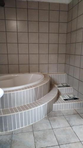 a white bathroom with a tub and some stairs at lrish Mist Estate in Howick