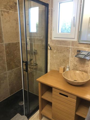 Un baño con ducha de cristal y lavabo. en Maison de charme, en Monteux