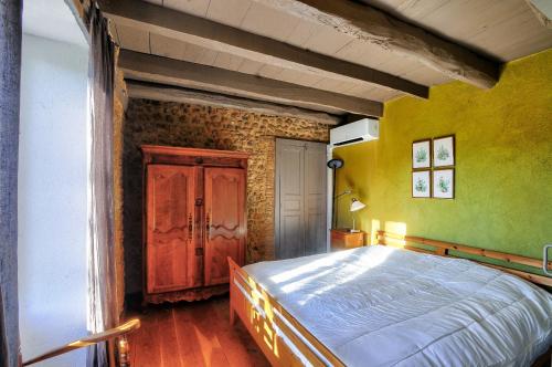 a bedroom with a large bed and yellow walls at Au coeur de la Dordogne, maison pour 6, piscine in La Pinsonnie